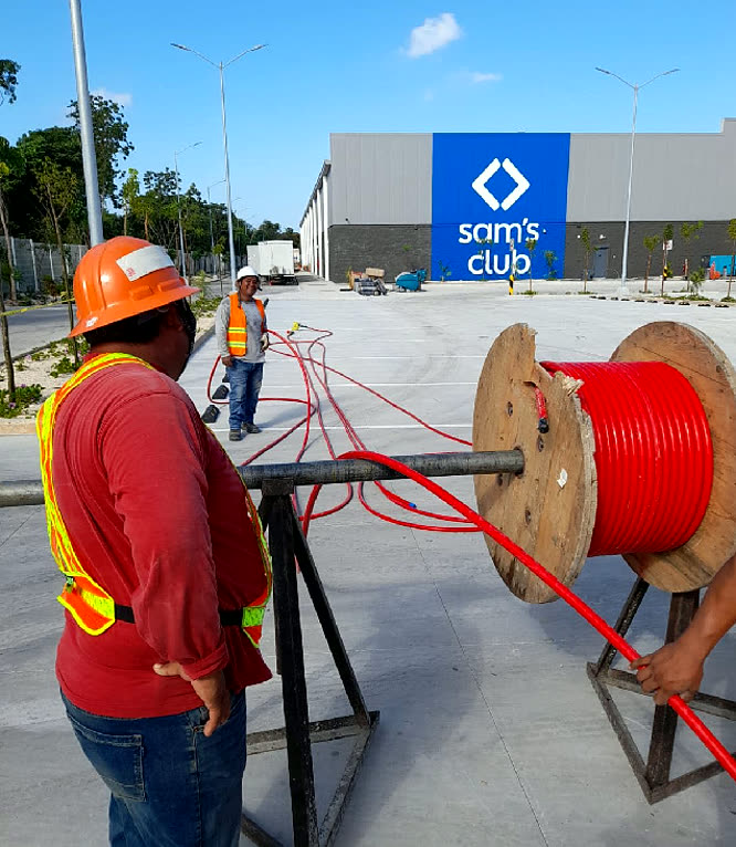 Cuadrilla tendiendo cable de media tensión frente a la fachada de Sam’s Club