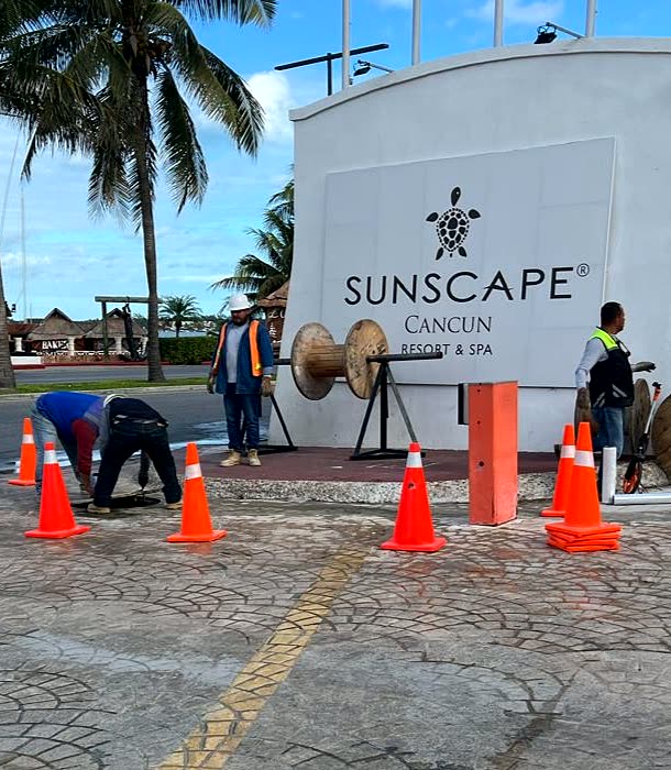 Cuadrilla con carretes de cable trabajando frente al acceso de Sunscape Cancún