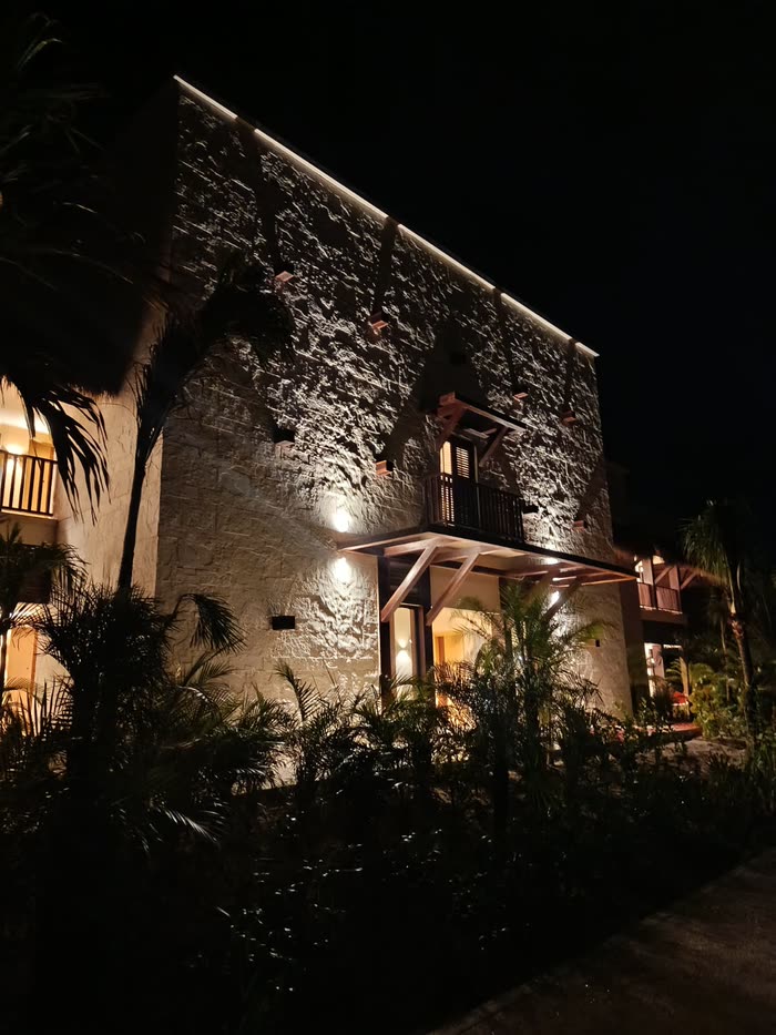 Fachada de piedra del Valentín Imperial iluminada de noche, con balcones de madera